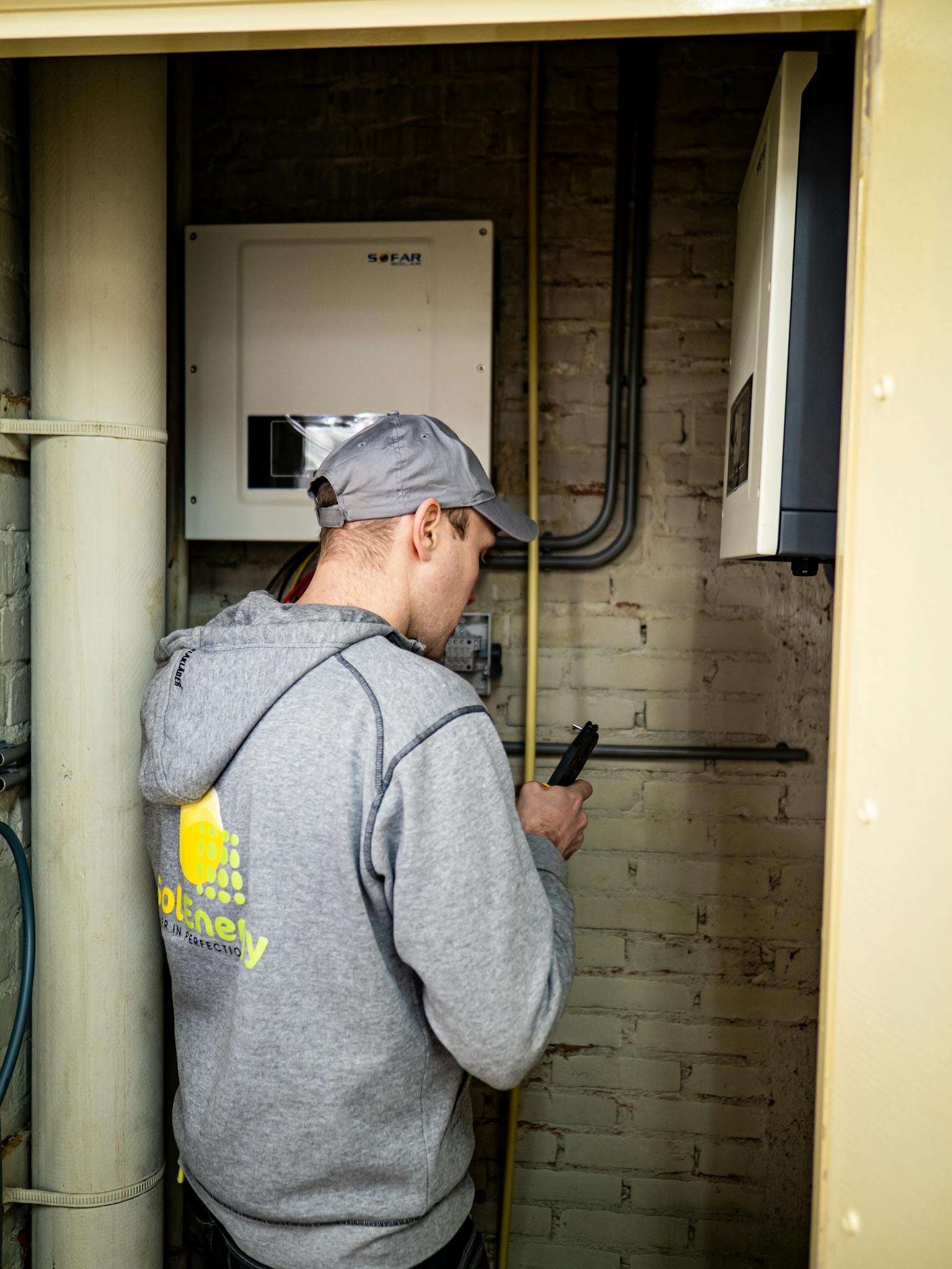 A technician examines solar power installations indoors, ensuring optimal performance.